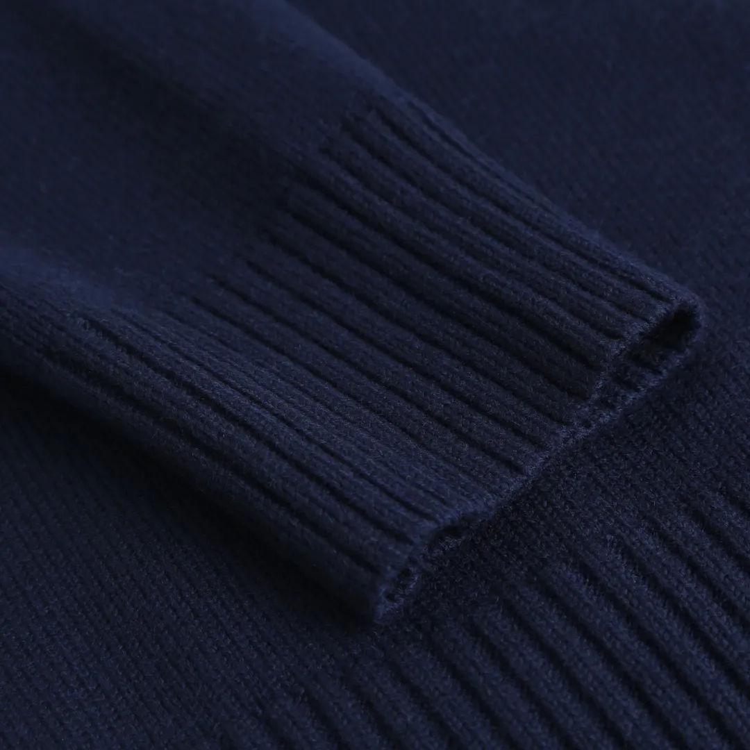 Ami love V-neck knitted cardigan is made of four-dimensional blended yarn of selected wool + cotton and nylon spandex. Each strand of yarn has undergone a "triple compound twisting" process. The wool provides natural warmth and fluffy feeling. After descaling treatment, combined with the smoothness of cotton fiber, it is close to the skin without any itch and is friendly to sensitive skin. The addition of nylon and spandex increases the fabric's rebound properties by 40%, making it less likely to wrinkle after long-term wear, and it still maintains its fluffy silhouette after machine washing. After blending, it feels soft and waxy, breaking the rough impression of traditional wool. The ADC pattern on the chest uses double-layer jacquard technology and is woven with milky white yarn. The stitch length changes to form a "cloud-like" three-dimensional texture. The edge of the pattern adopts "gradient narrowing" technology. The density of stitches from the center to the edge is from dense to sparse, giving a hazy feeling of natural smearing. The weight of the yarn in the jacquard area is 280g/m², which is 20% higher than the main body of the garment. It feels thick and full, highlighting the relief texture of the pattern. The neckline, cuffs, and hem are all made of thickened ribs, and the stitch density reaches 12 stitches per centimeter, forming a tight and elastic closing. The rib edges are added with 1% spandex and processed with "pre-shrinking and shaping" to ensure that they will not loosen or deform after multiple washings. The neckline is a V-neck design with an angle of 60°, and is paired with double-layered ribbing, which not only modifies the neck line but also enhances wearing stability. It adopts an Oversize silhouette, with the length reaching to the hips, and the overall lines are round and smooth. The two sides of the body are "slightly tightened" to retain the waistline while being loose and avoid feeling bloated. Size:S-M-L-XL